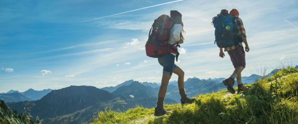 Two hikers walking up a hill on a sunny day